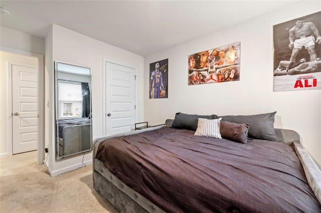 bedroom with baseboards and light colored carpet