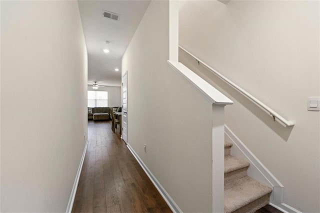 hall featuring recessed lighting, dark wood-style flooring, visible vents, baseboards, and stairs