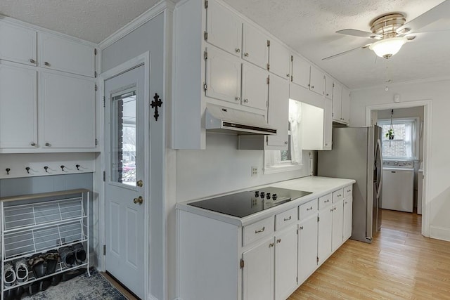 kitchen featuring black electric stovetop, a textured ceiling, light hardwood / wood-style flooring, and white cabinets