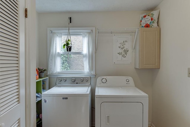 laundry room with cabinets, independent washer and dryer, and a textured ceiling