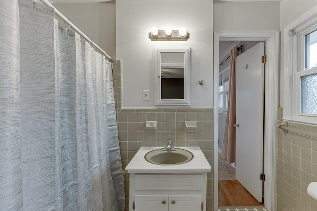 bathroom featuring hardwood / wood-style flooring, vanity, and tile walls