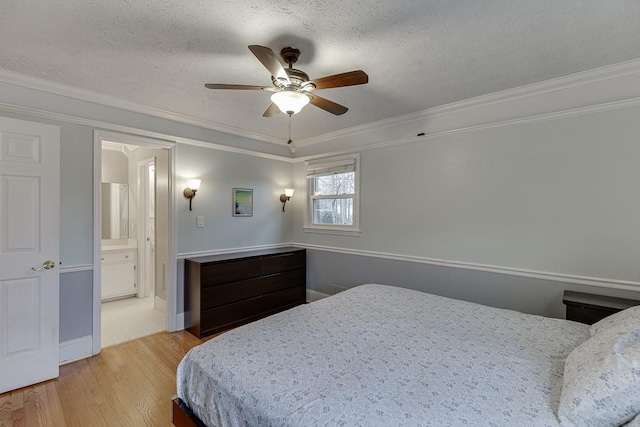 bedroom with crown molding, light hardwood / wood-style flooring, ensuite bath, ceiling fan, and a textured ceiling