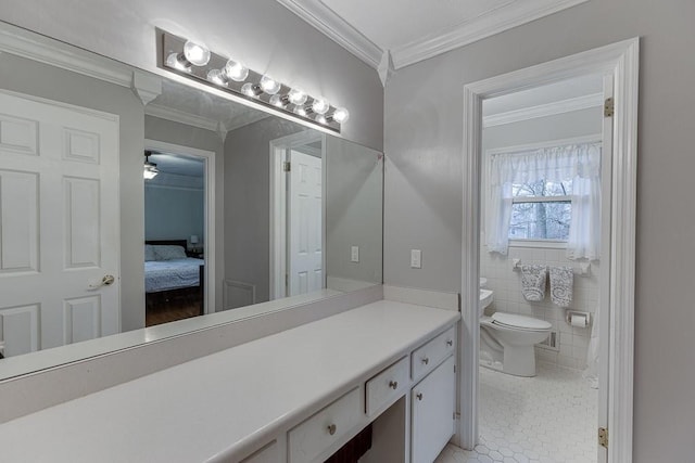 bathroom featuring toilet, tile walls, ornamental molding, vanity, and tile patterned flooring