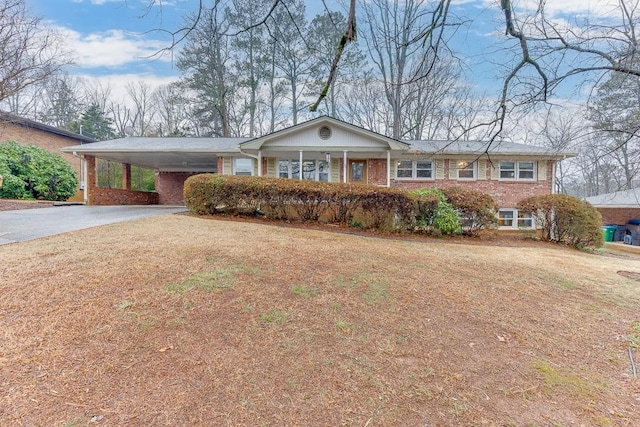 ranch-style home featuring a carport and a front yard