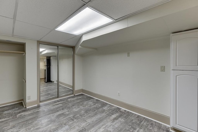 basement with wood-type flooring and a drop ceiling