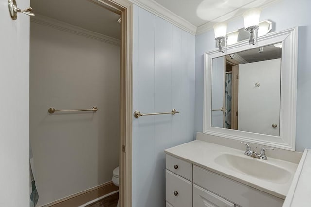 bathroom featuring vanity, ornamental molding, and toilet