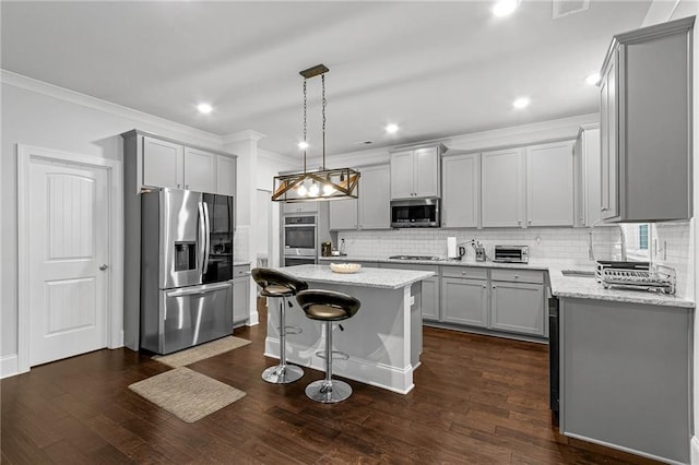 kitchen with stainless steel appliances, gray cabinets, dark wood-type flooring, and a kitchen island