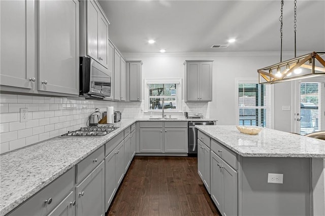 kitchen with gray cabinets, visible vents, decorative backsplash, appliances with stainless steel finishes, and dark wood-type flooring