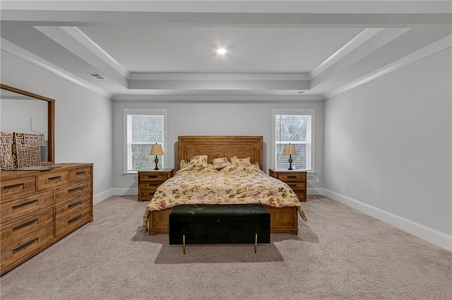 bedroom featuring a raised ceiling, multiple windows, and baseboards