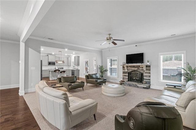 living room featuring ornamental molding, a fireplace, and a wealth of natural light