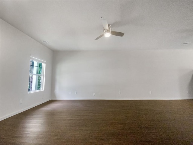 empty room with dark hardwood / wood-style floors and ceiling fan