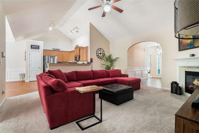 1856 Temple Park Dr, Loganville, GA 30052 - living room with arched walkways, light colored carpet, a ceiling fan, a decorative wall, and track lighting