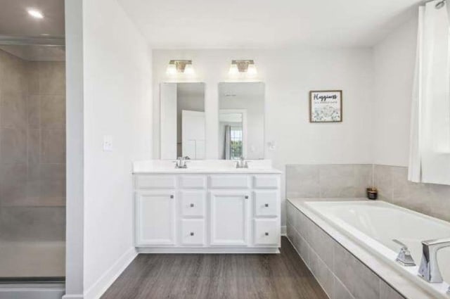 bathroom with vanity, wood-type flooring, and plus walk in shower