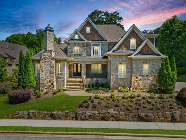 craftsman inspired home with metal roof, a porch, a front lawn, a standing seam roof, and a chimney