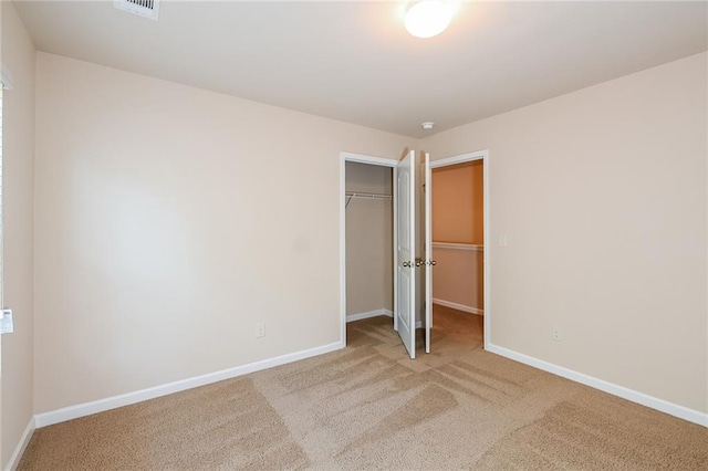 unfurnished bedroom with a closet and light colored carpet