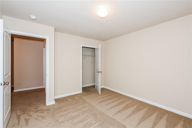 unfurnished bedroom featuring light colored carpet and a closet