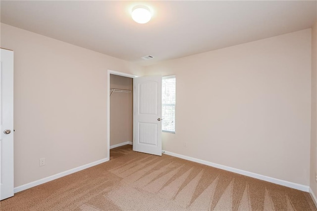 unfurnished bedroom featuring carpet floors and a closet