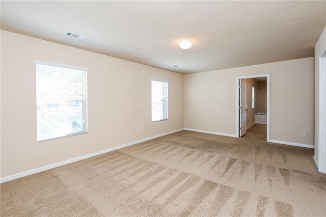 empty room with light carpet and a wealth of natural light