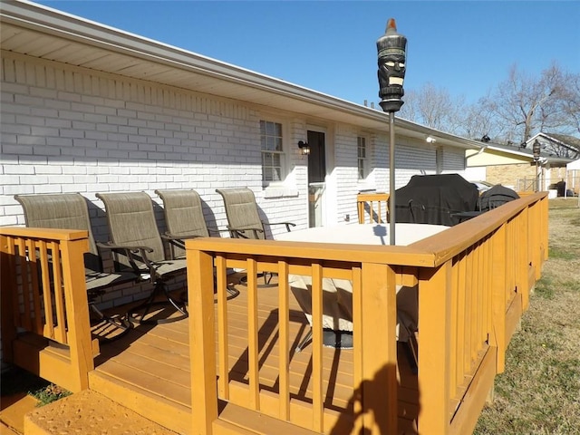 wooden deck featuring a grill