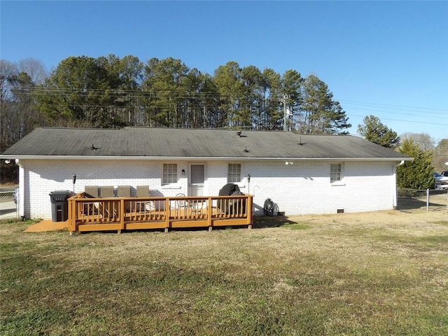 rear view of house featuring a deck and a lawn