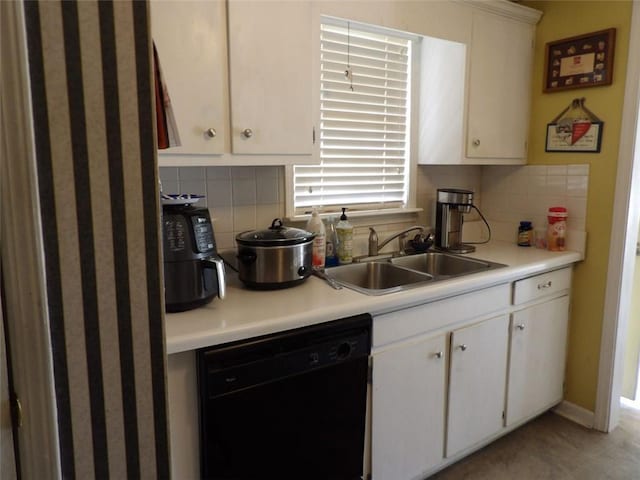 kitchen with black dishwasher, sink, white cabinets, and decorative backsplash