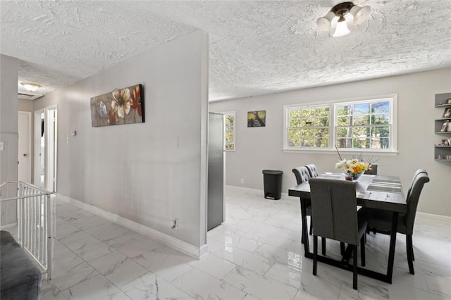 dining space with a textured ceiling