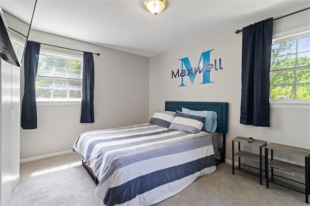 carpeted bedroom featuring multiple windows