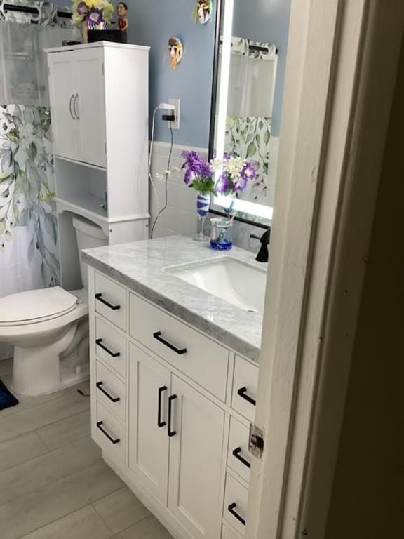 bathroom with vanity, a shower with shower curtain, toilet, and tile patterned floors