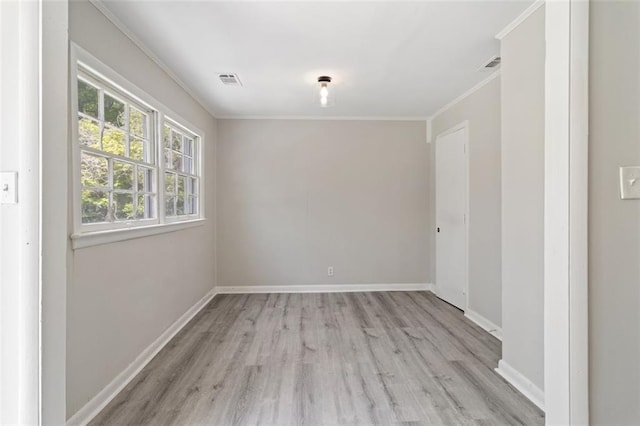 empty room with ornamental molding and light hardwood / wood-style floors