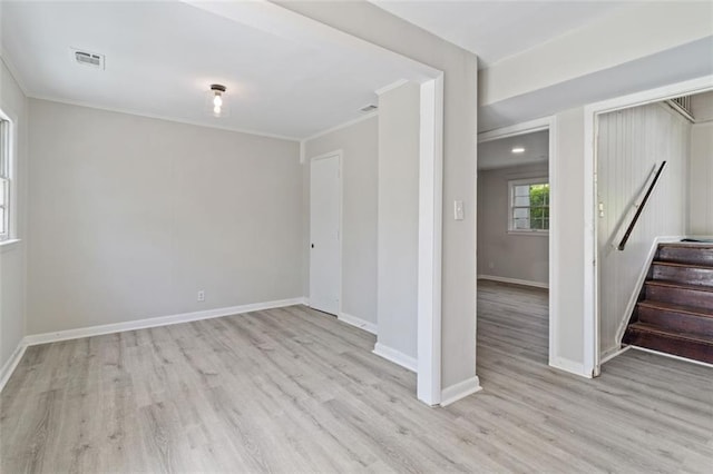 spare room with light hardwood / wood-style floors and crown molding