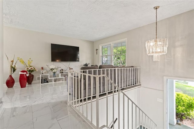 interior space with a notable chandelier and a textured ceiling