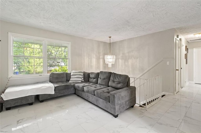 living room featuring a notable chandelier and a textured ceiling