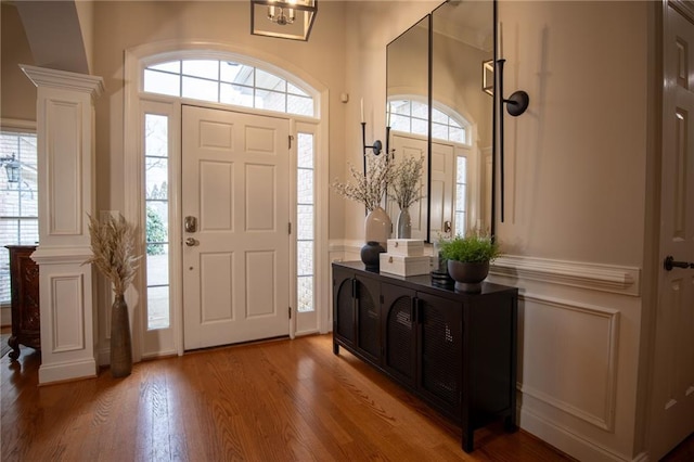 entrance foyer with decorative columns and wood-type flooring