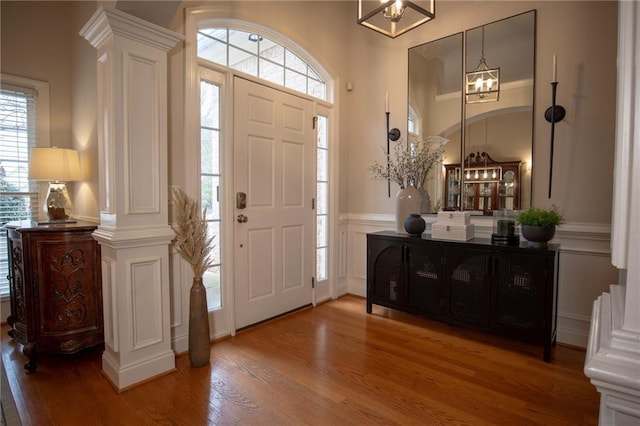 foyer entrance featuring hardwood / wood-style flooring and ornate columns