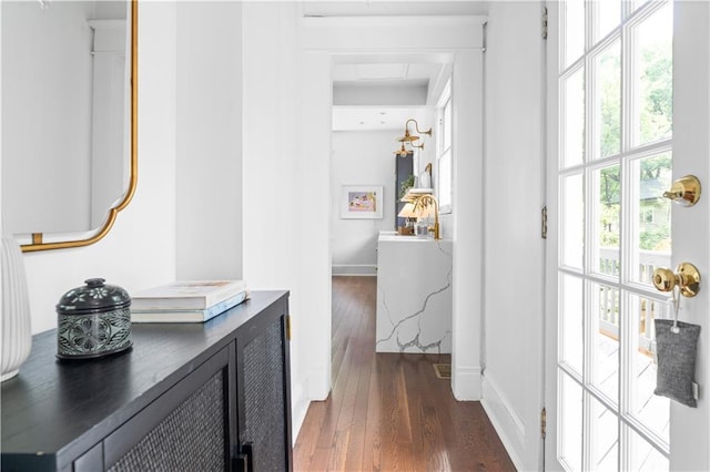 hallway with dark wood finished floors and baseboards