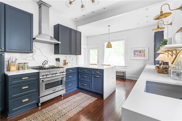 kitchen with high end stove, wall chimney exhaust hood, a peninsula, and dark wood-style floors