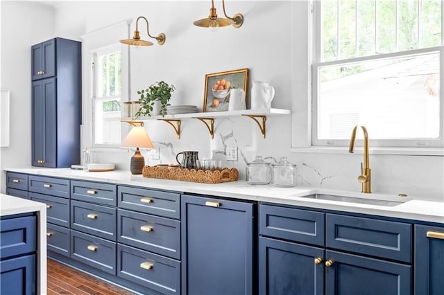 kitchen with open shelves, a sink, and blue cabinetry