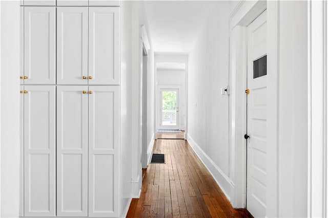 hall with dark wood finished floors and baseboards