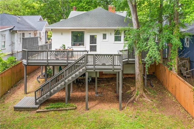 back of house featuring a fenced backyard, a wooden deck, and a chimney