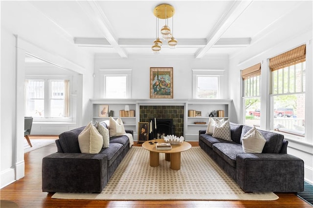 living room with wood finished floors, healthy amount of natural light, beam ceiling, coffered ceiling, and a tile fireplace