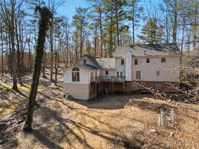 rear view of house featuring a wooden deck