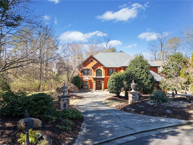 view of front of property with a balcony, driveway, and a shingled roof