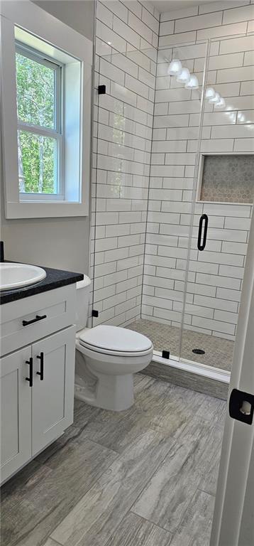 6093 Wayarer Dr, Villa Rica, GA 30180 - bathroom with a stall shower, toilet, vanity, and wood finished floors