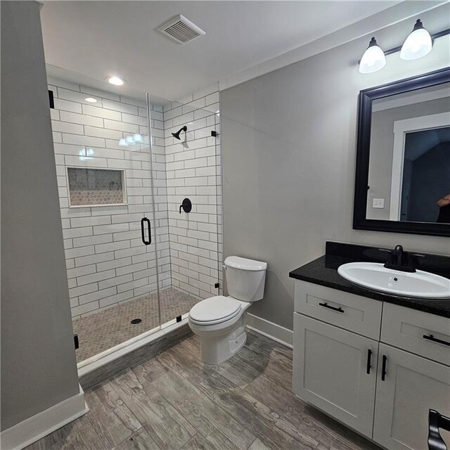 6093 Wayarer Dr, Villa Rica, GA 30180 - bathroom with toilet, a stall shower, baseboards, wood finished floors, and vanity