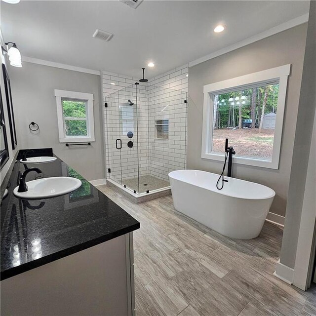 6093 Wayarer Dr, Villa Rica, GA 30180 - full bathroom with ornamental molding, a stall shower, double vanity, a soaking tub, and recessed lighting
