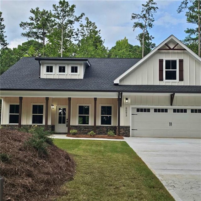 6093 Wayarer Dr, Villa Rica, GA 30180 - view of front facade featuring board and batten siding, a shingled roof, driveway, and stone siding