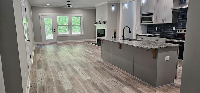6093 Wayarer Dr, Villa Rica, GA 30180 - kitchen featuring a sink, appliances with stainless steel finishes, open floor plan, a ceiling fan, and crown molding