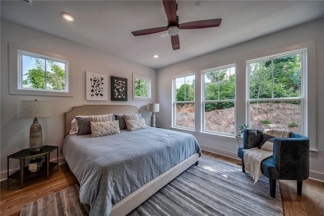 bedroom with hardwood / wood-style flooring, multiple windows, and ceiling fan