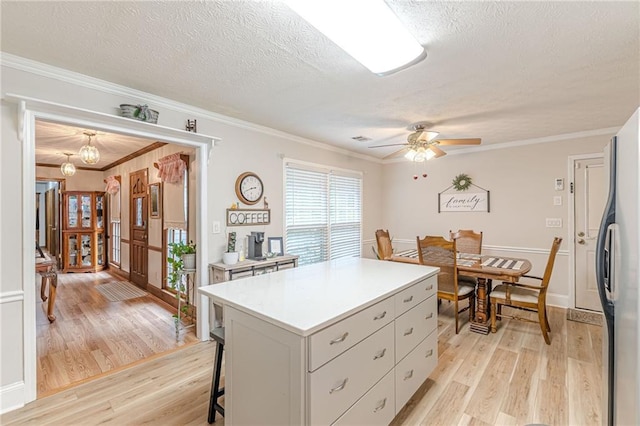 1667 Quail Run, Conyers, GA 30094 - kitchen with a textured ceiling, fridge, light wood-style floors, ornamental molding, and light countertops