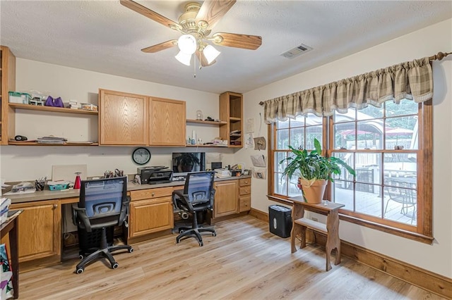 1667 Quail Run, Conyers, GA 30094 - office space featuring built in desk, ceiling fan, light wood-style flooring, and a textured ceiling